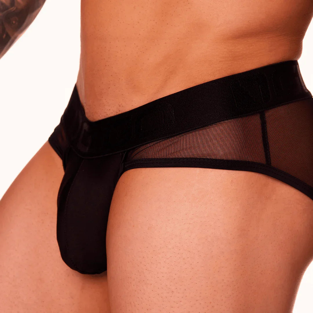 Close-up of a black Gigo Mediterranean brief showing the front pouch, wide waistband and sheer side panel.